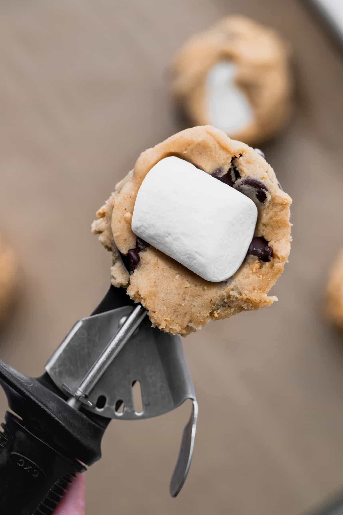 Marshmallow on top of cookie dough scoop.