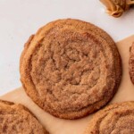 Chewy peanut butter cookie dipped in cinnamon sugar on parchment paper.