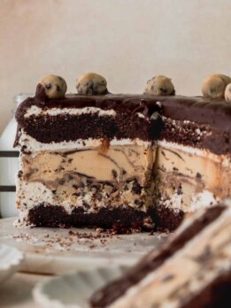 Cookie dough ice cream cake on a marble board cut into.