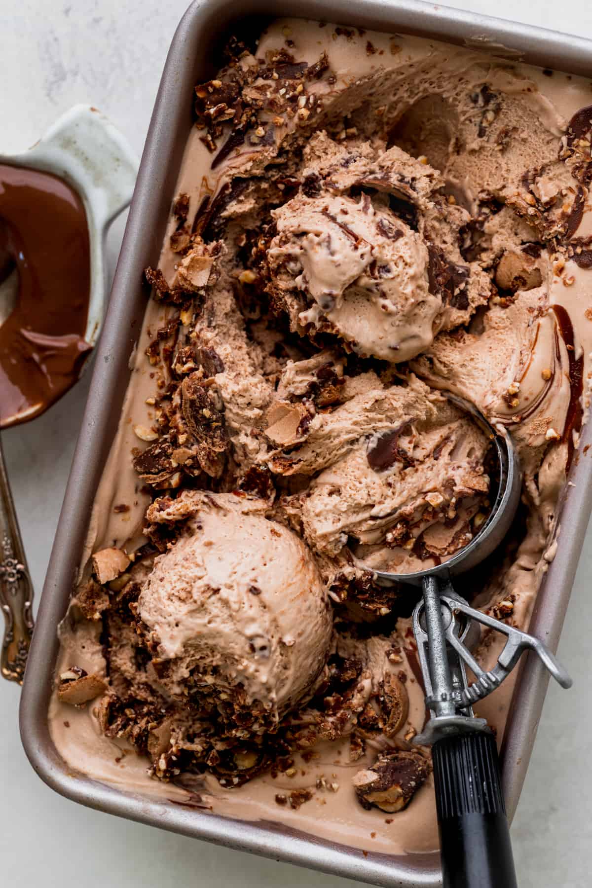 Nutella ice cream in a tin with an ice cream scoop.