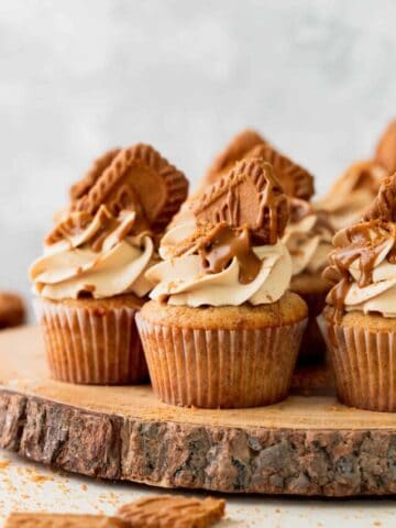 Biscoff cupcakes on a wooden platform.