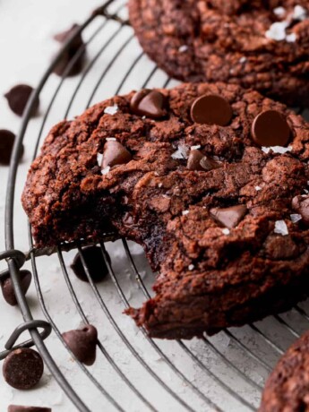 A bite missing from a brownie crinkle cookie.