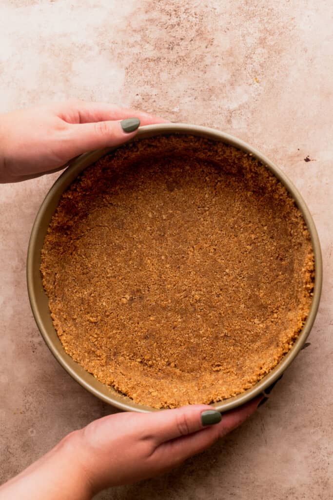 Graham cracker crust in a springform pan.