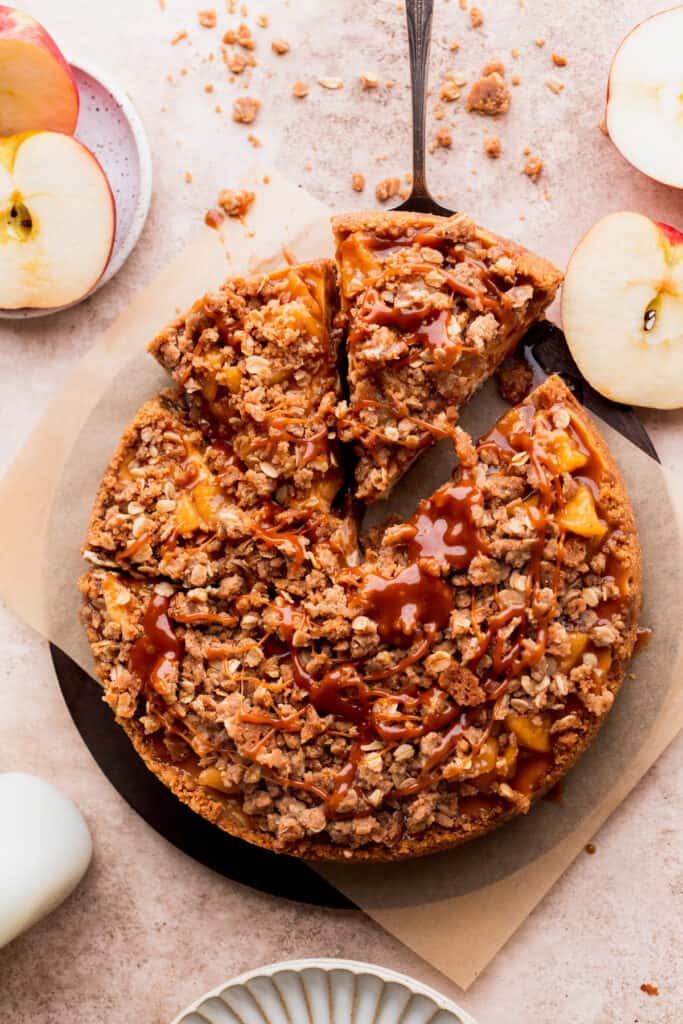Top view of apple crumble cheesecake taking a slice out.