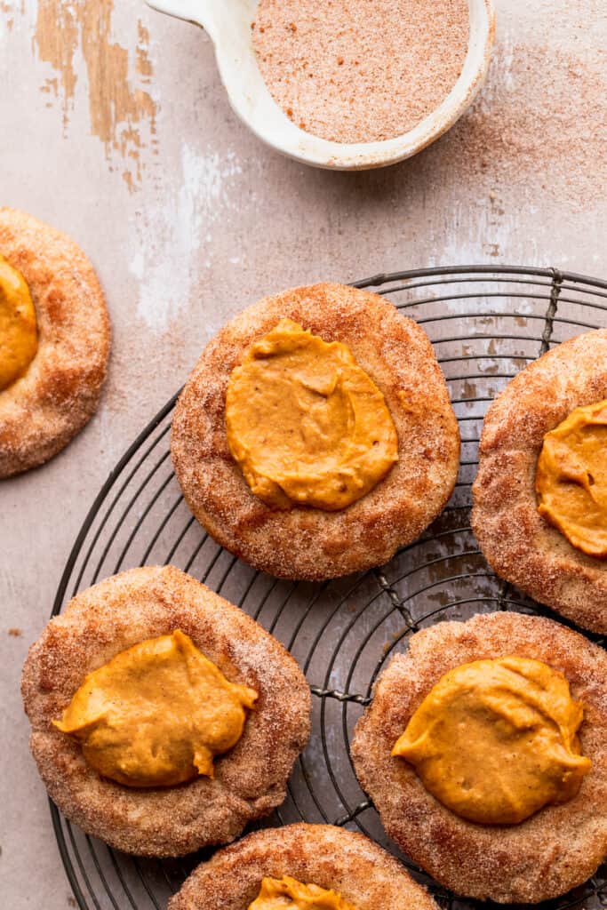Pumpkin pie cookies on a wire rack topped with cinnamon sugar.