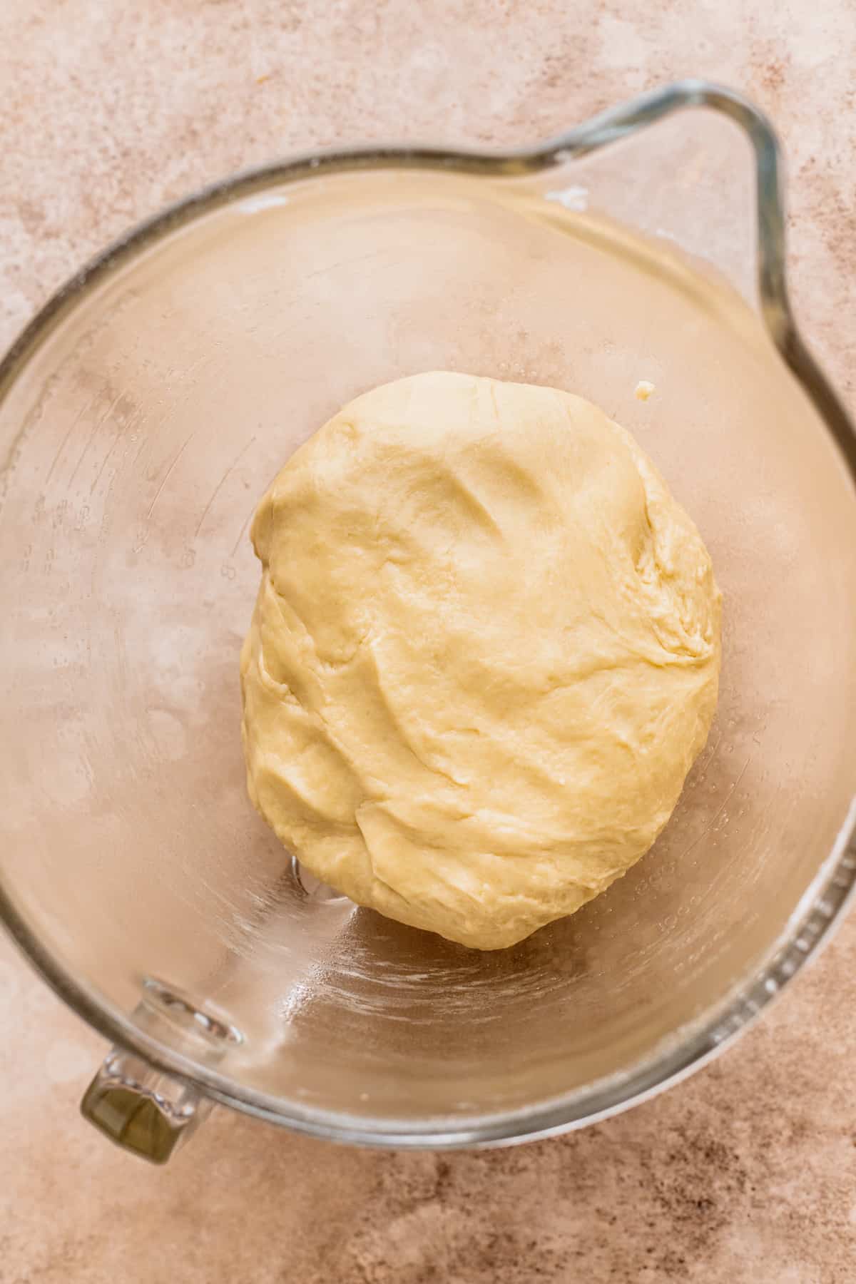 Dough before it rose in a glass bowl.