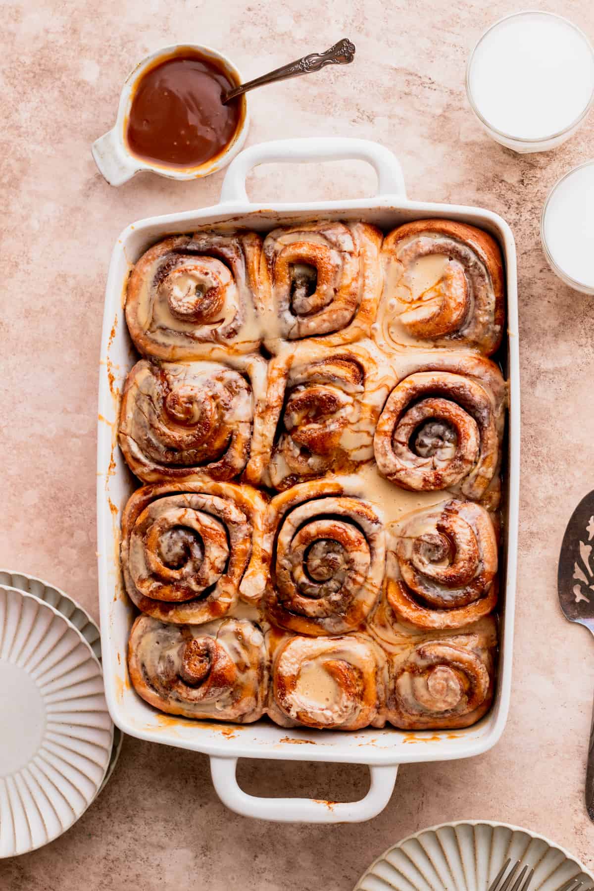 Cinnamon rolls in a pan topped with caramel.