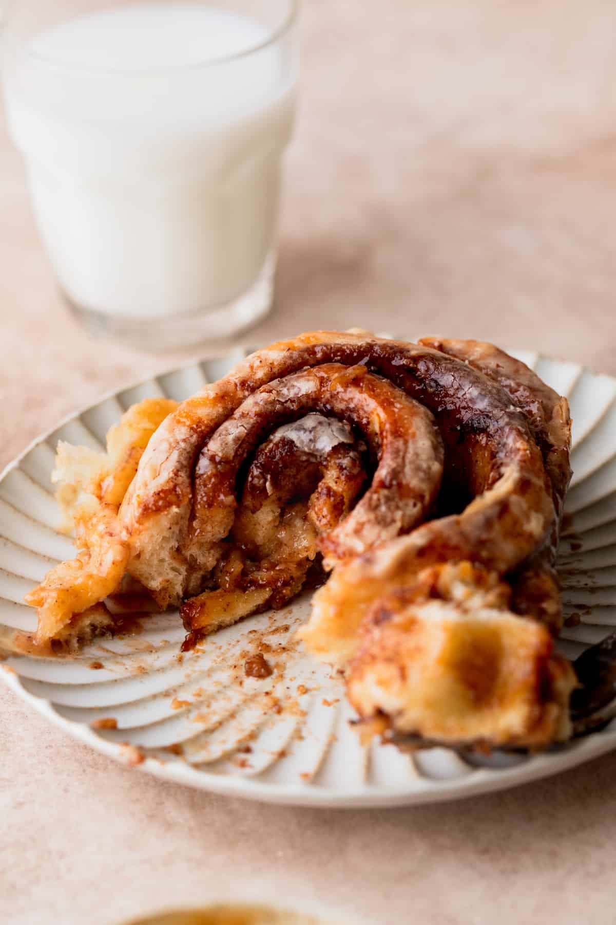 A bite missing from caramel cinnamon roll.