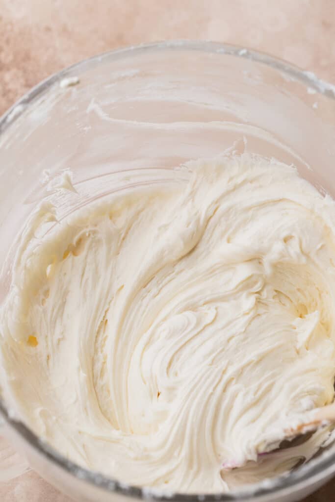 Cream cheese frosting in a glass bowl.