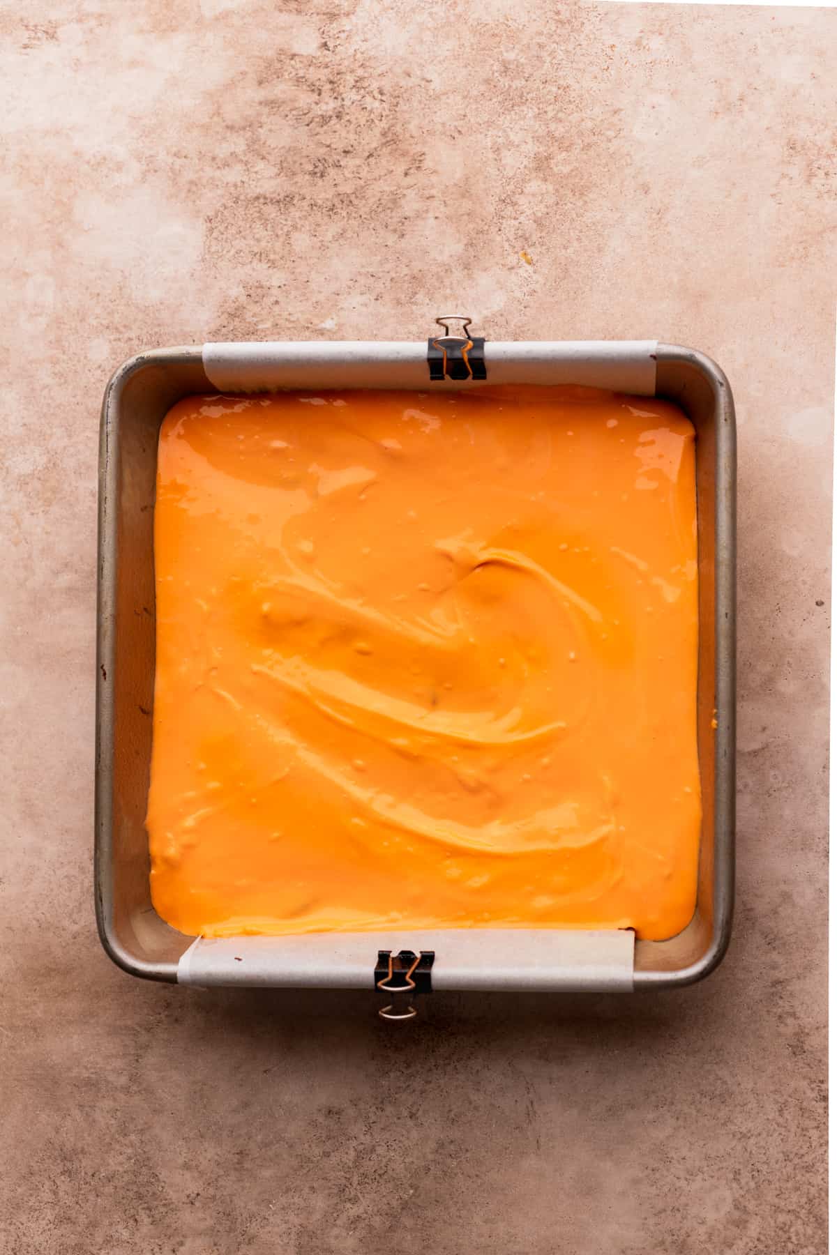 Orange cheesecake on top of the brownie batter.