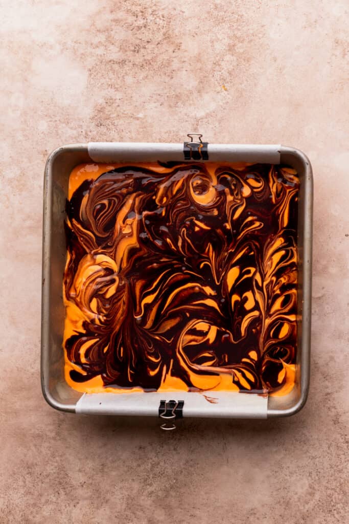 Swirled brownie batter in a pan.