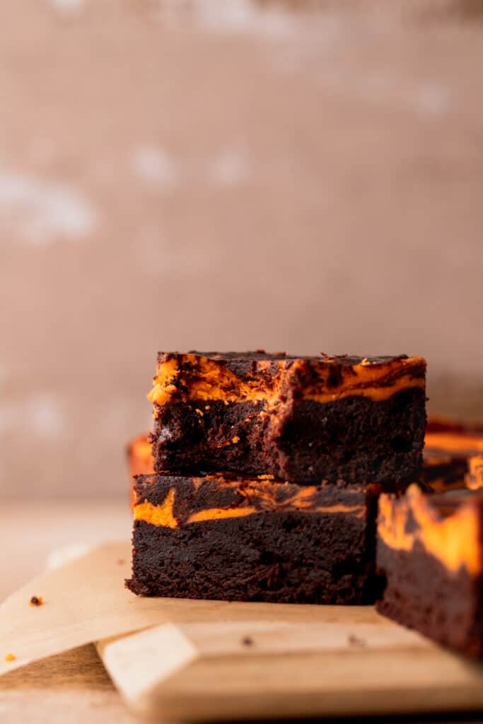 Stack of brownies with one bite missing.