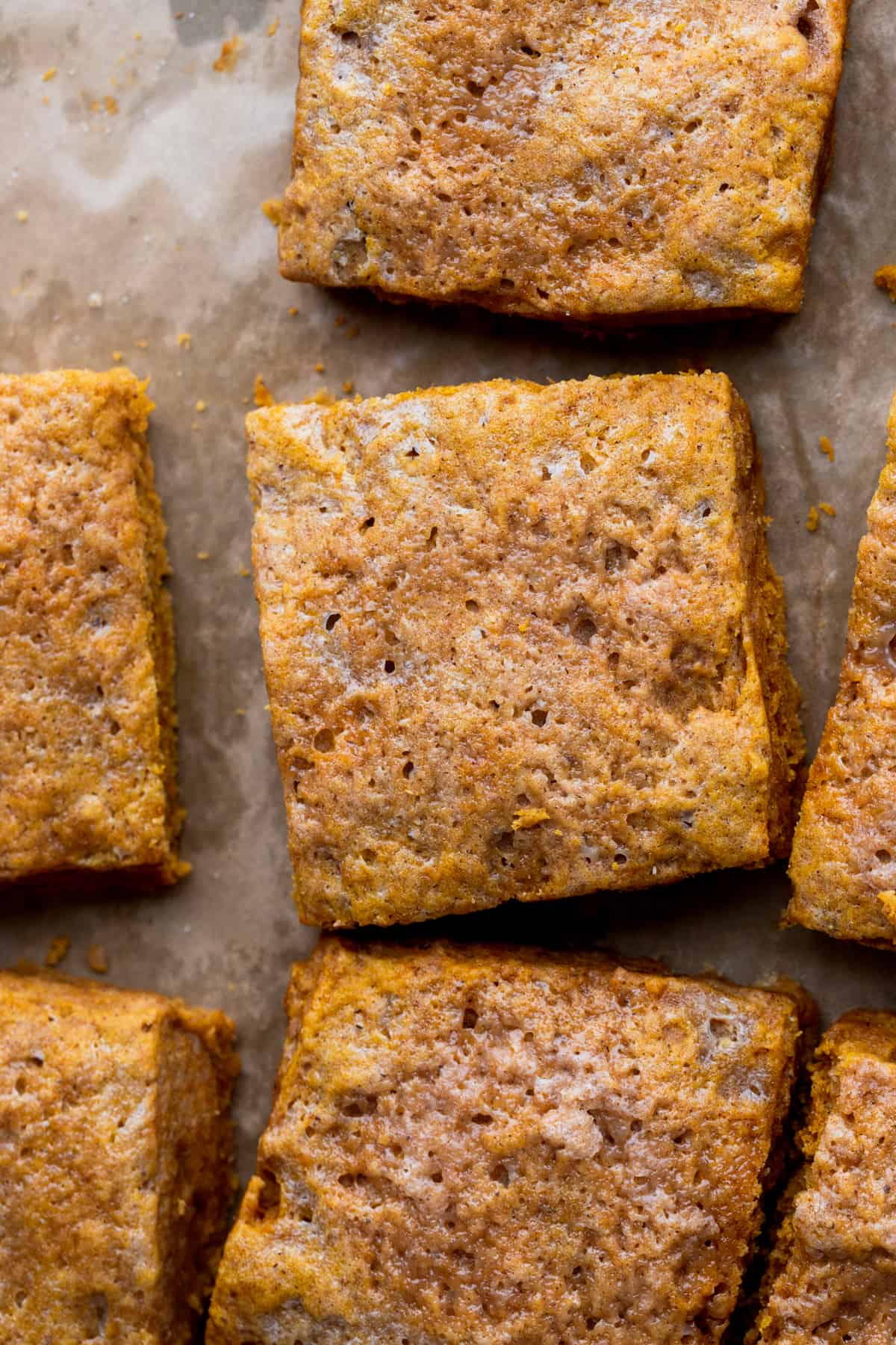 Baked square scones on a parchment paper.