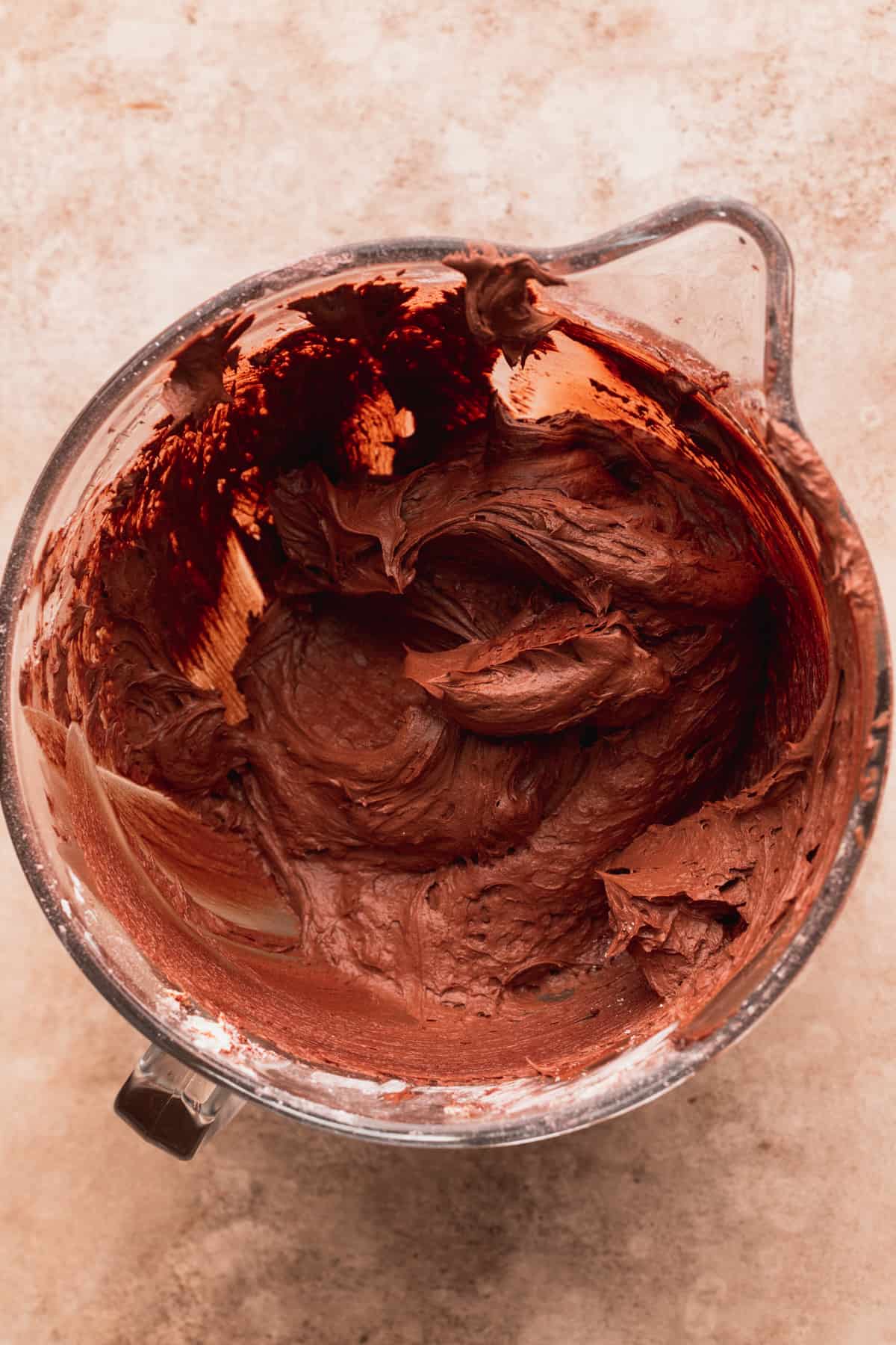 Chocolate frosting in a glass bowl.