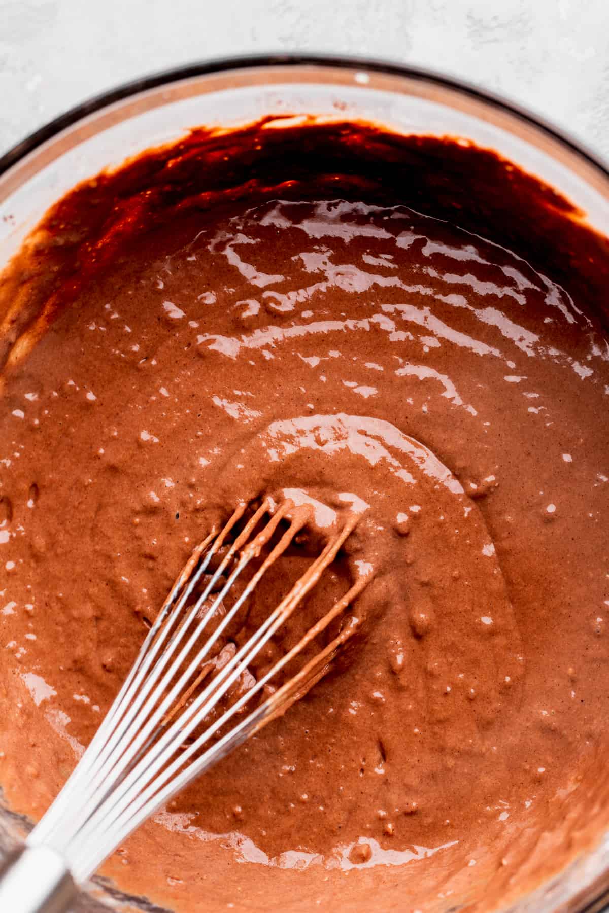 Chocolate pancake batter in a glass bowl.