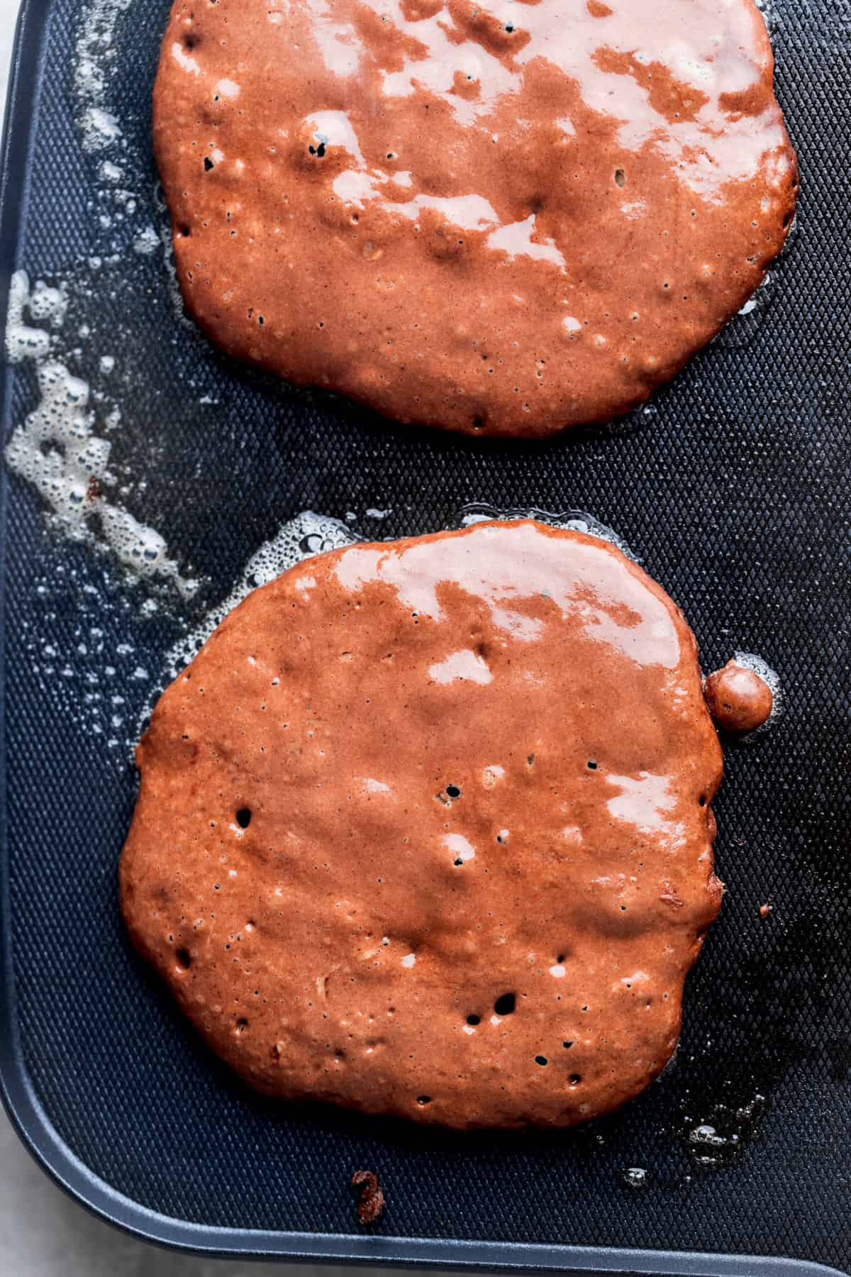 Pancake batter on top of hot griddle.