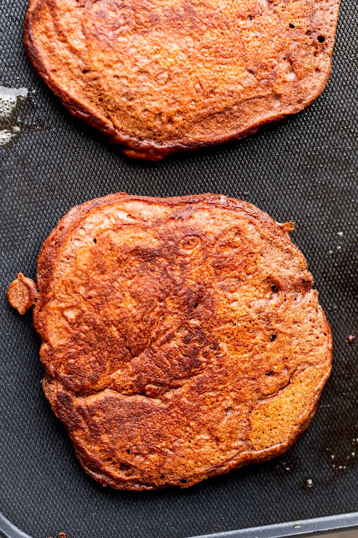 Cooked pancake on a hot griddle.