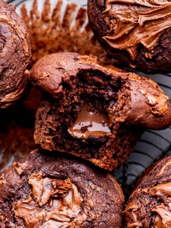 Nutella muffins with a bite missing on a wire rack.