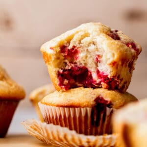 Two raspberry muffins stacked on top of each other.