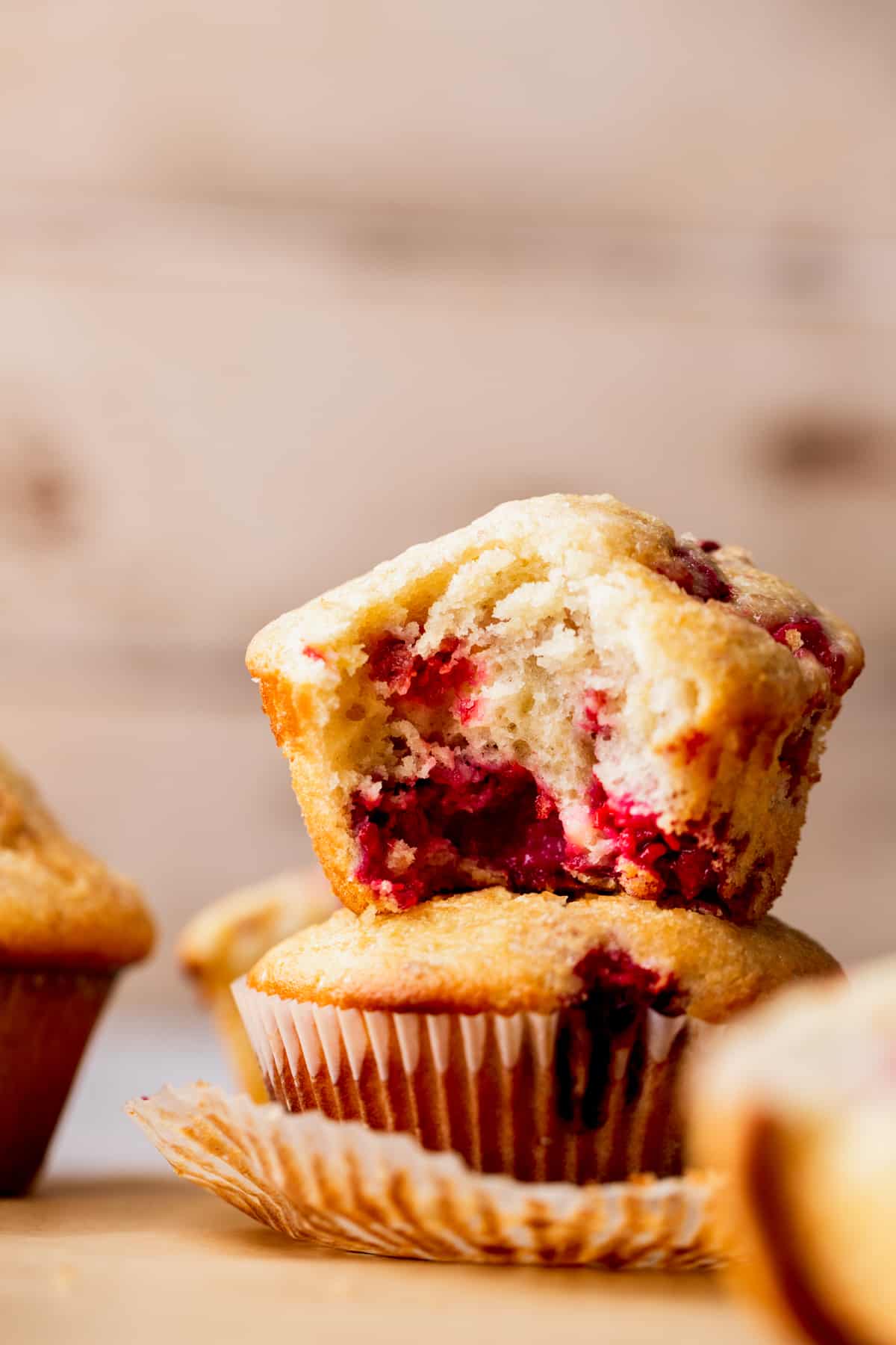 Two raspberry muffins stacked on top of each other.