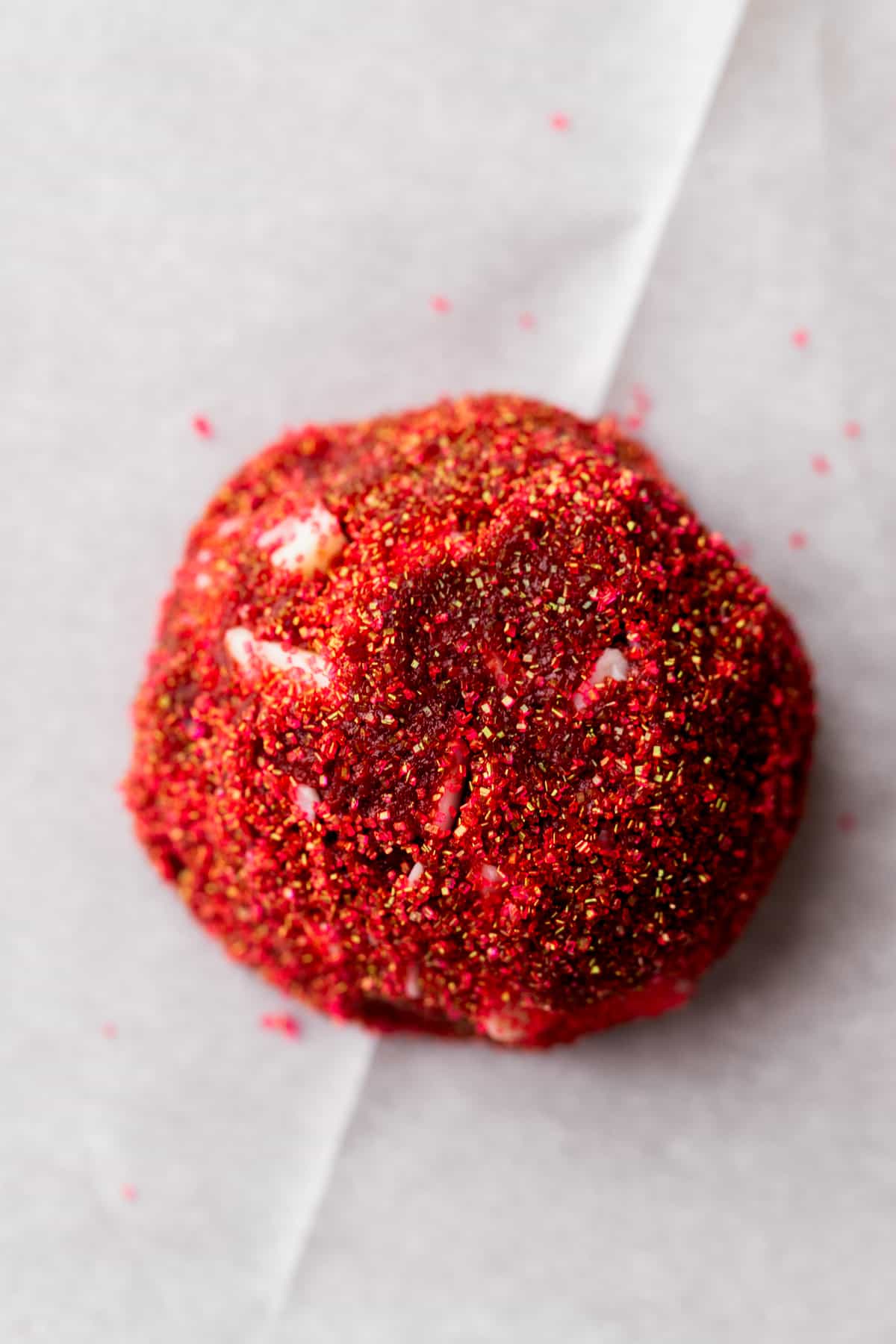 Cookie dough ball covered in red sugar.