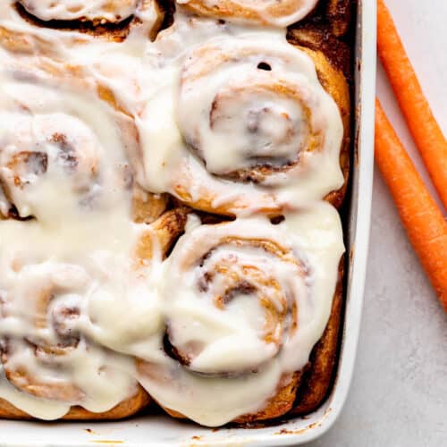 Carrot cake cinnamon rolls in a pan.