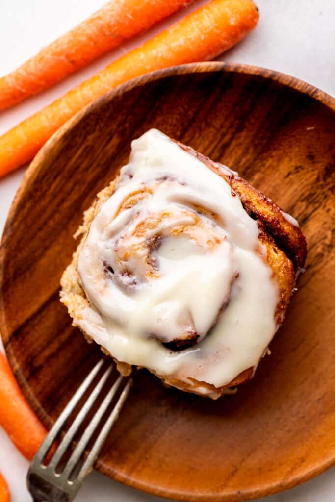 One carrot cake cinnamon roll on a plate.