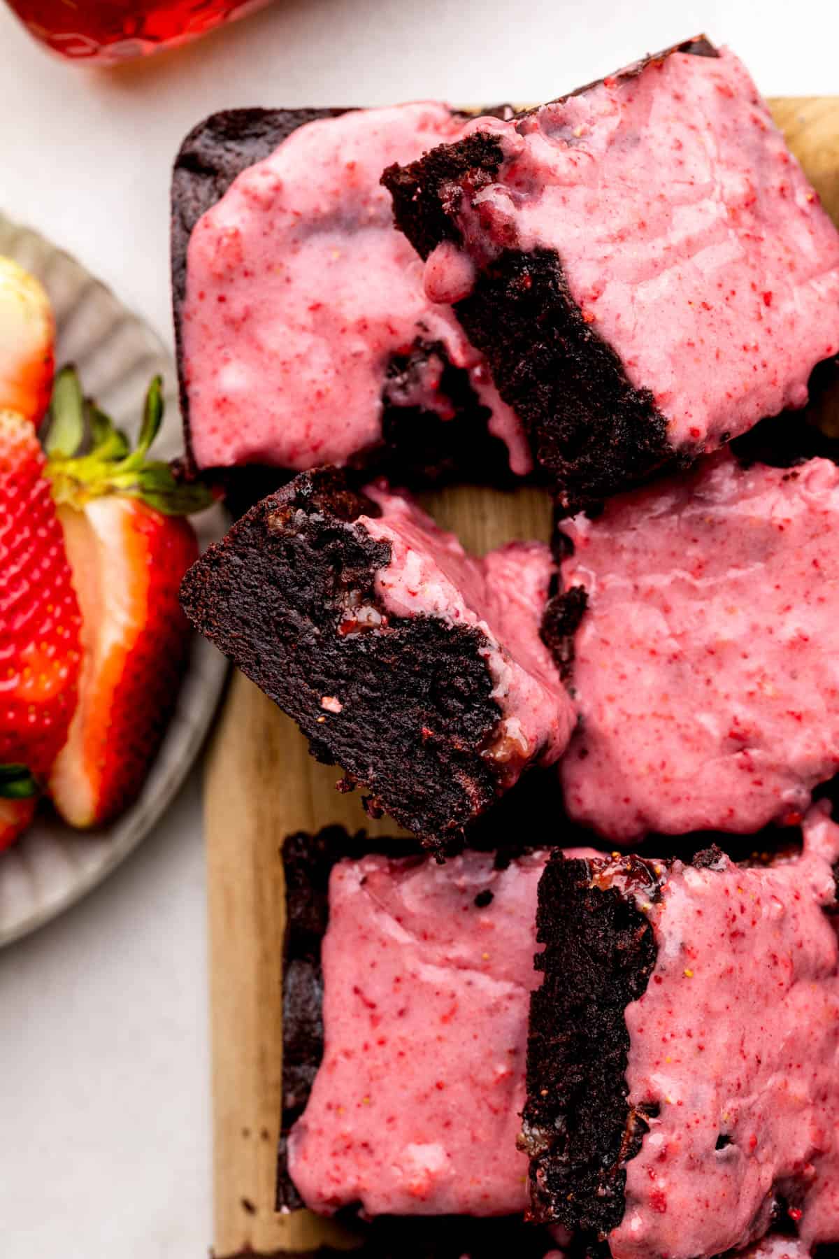 Close up of a strawberry brownie on a wood board.
