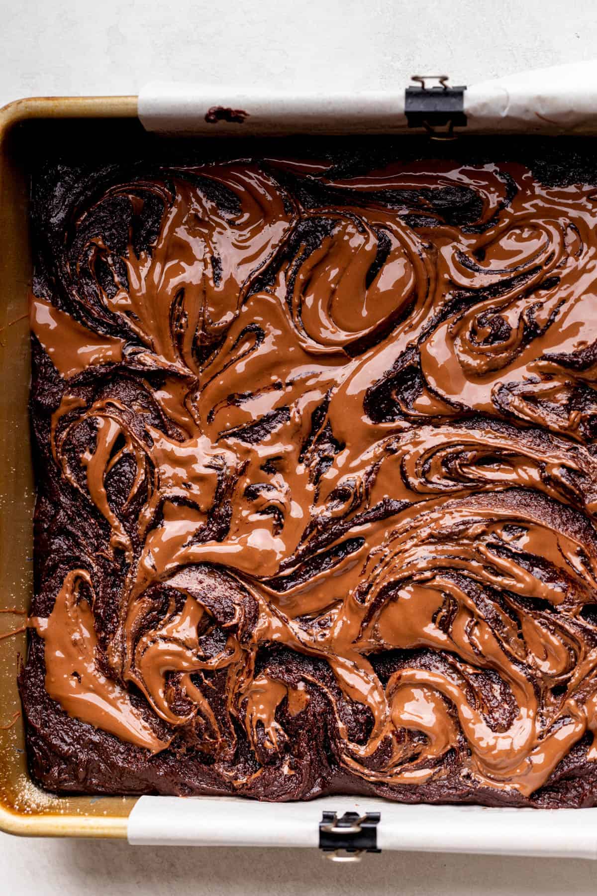 Swirled Nutella on top of brownie batter.