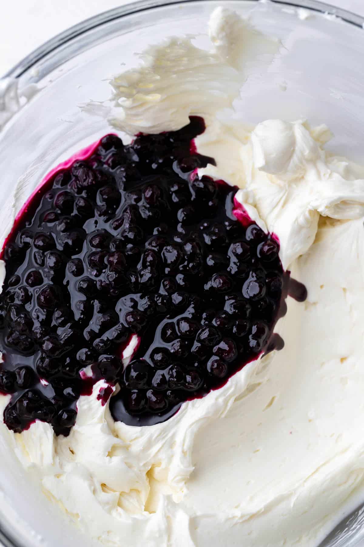 Blueberry sauce on top of cheesecake batter.