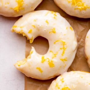 One bite missing from lemon donuts.