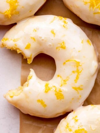 One bite missing from lemon donuts.