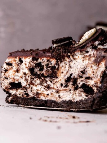 One slice of no bake oreo cheesecake on a pie cutter.