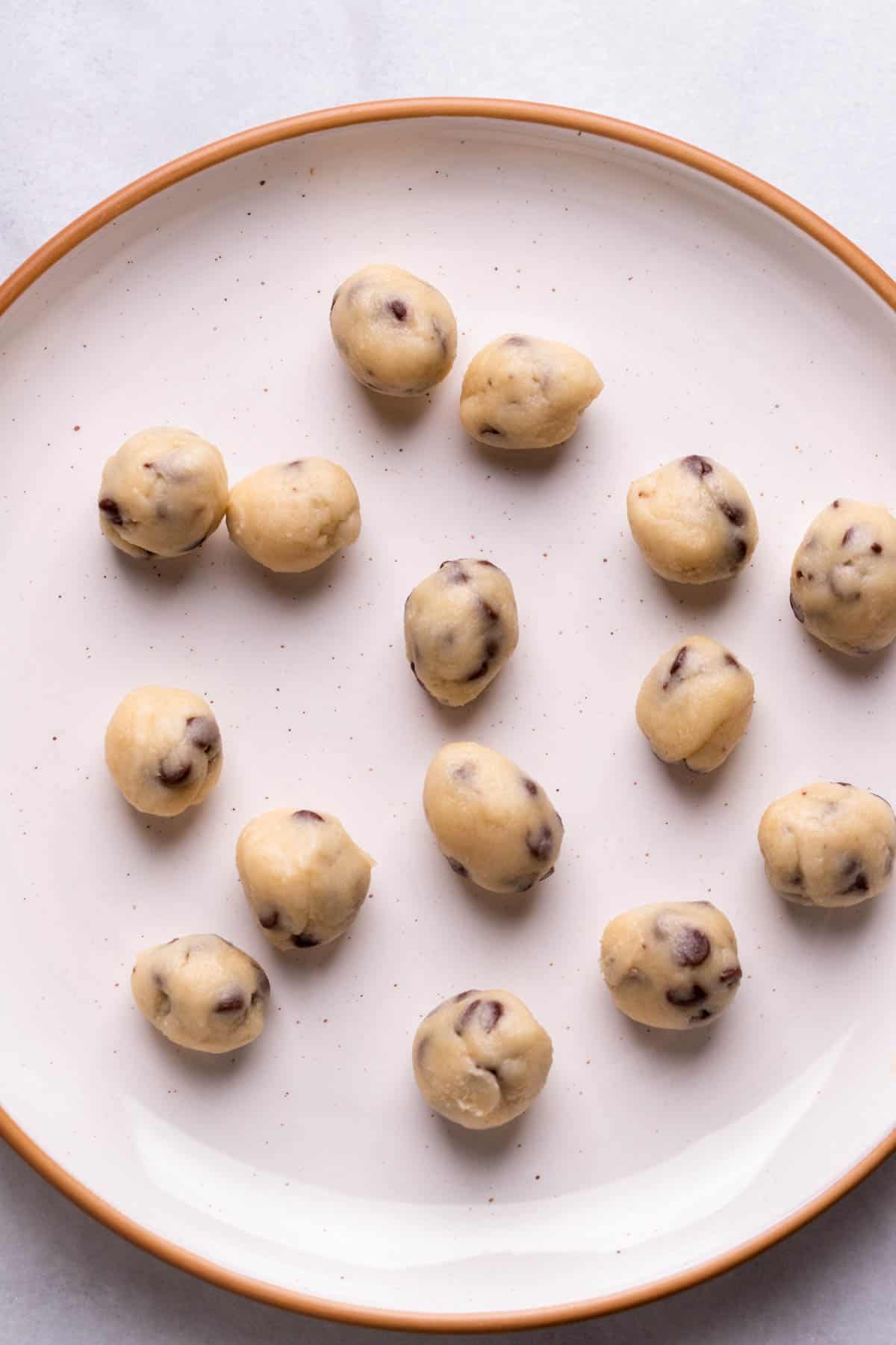 Rolled cookie dough balls on a plate.