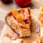 Fork inserted into a peach cheesecake slice.