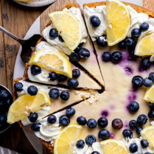 Decorated lemon blueberry cheesecake on a board.
