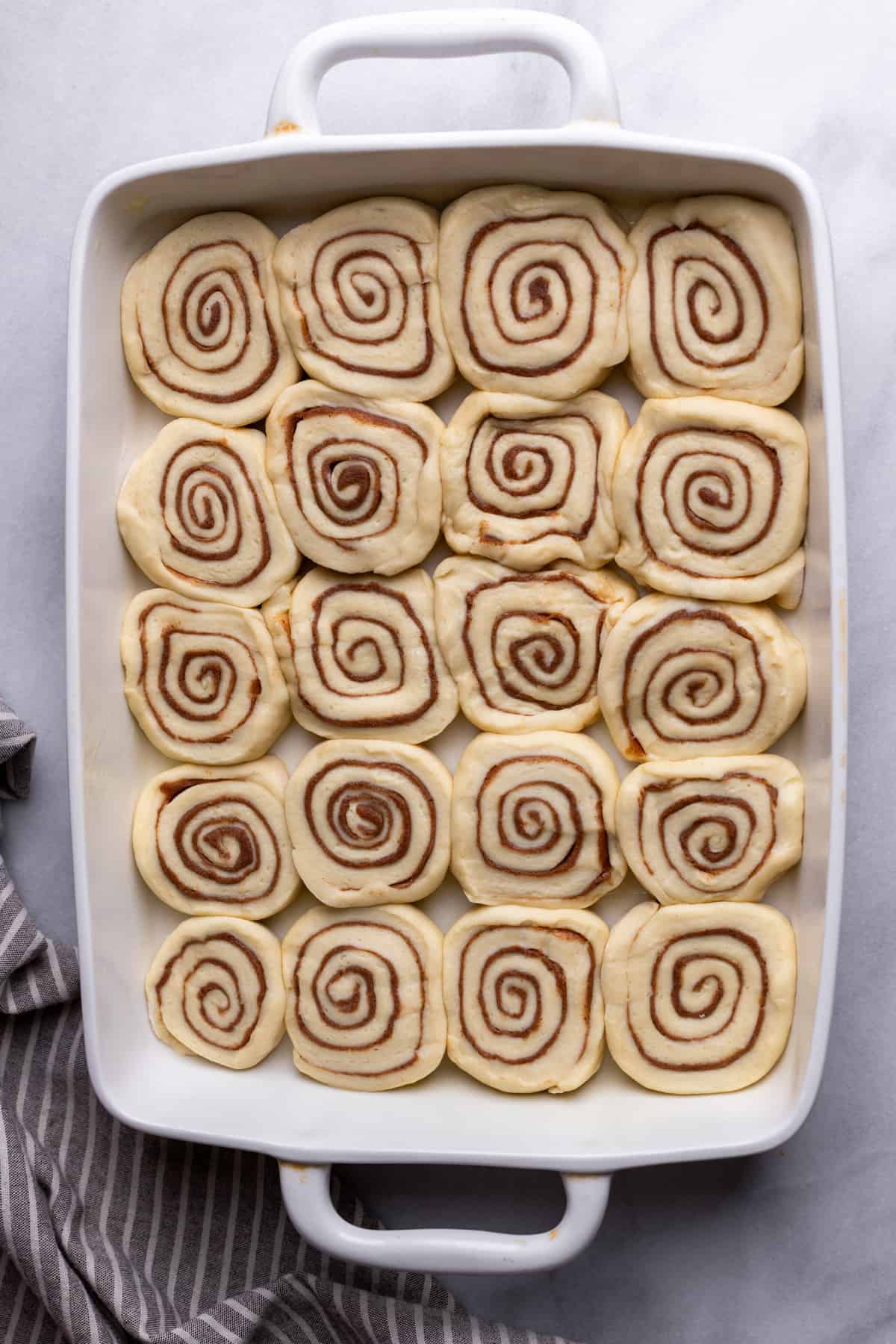 Raw cinnamon rolls in a pan.