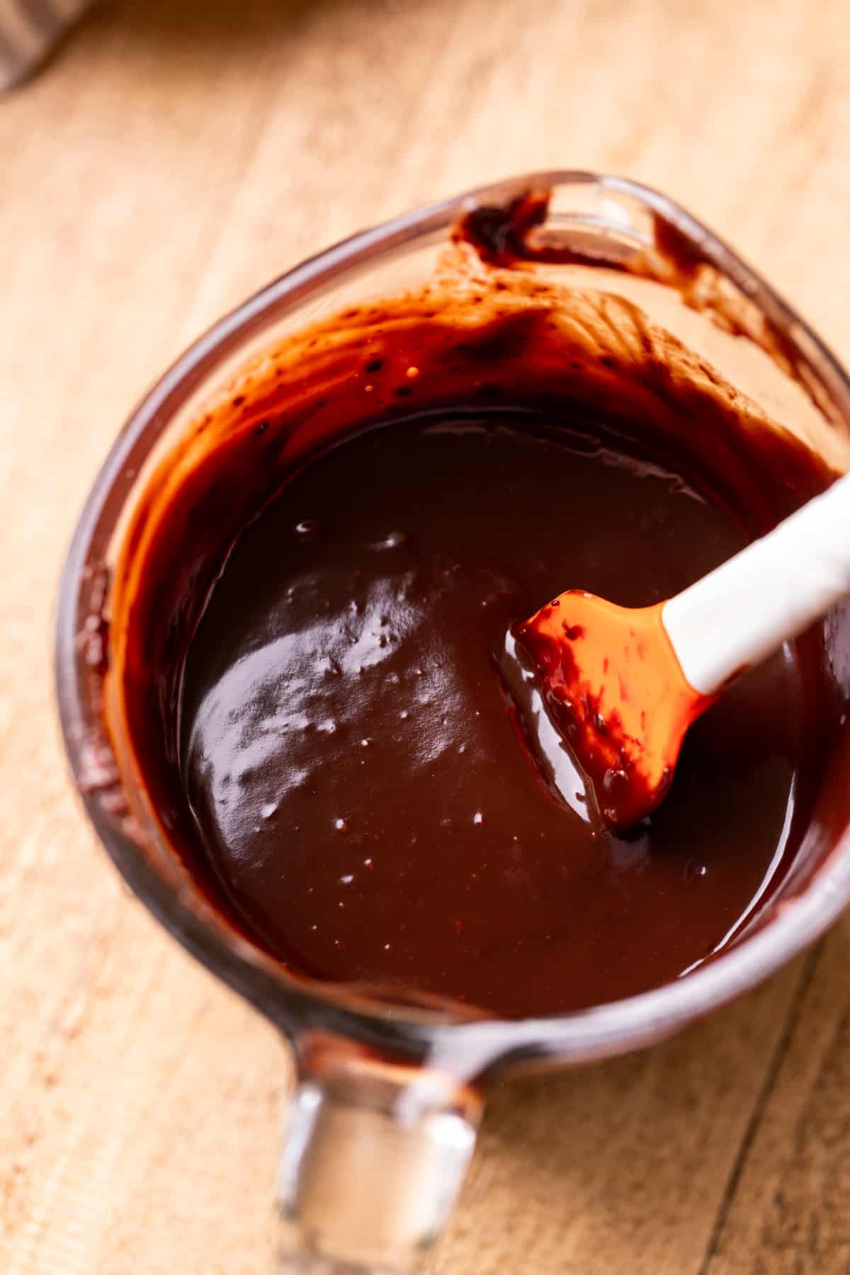Chocolate glaze in a glass measuring cup.