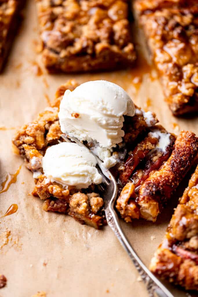Ice cream on top of a slice of puff pastry apple tart.