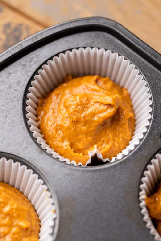 Pumpkin batter in a muffin pan.