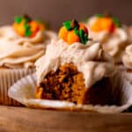 Bite missing from a pumpkin cupcake.