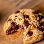 Bite missing from butterscotch chocolate chip cookies.