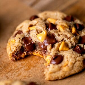 Bite missing from butterscotch chocolate chip cookies.
