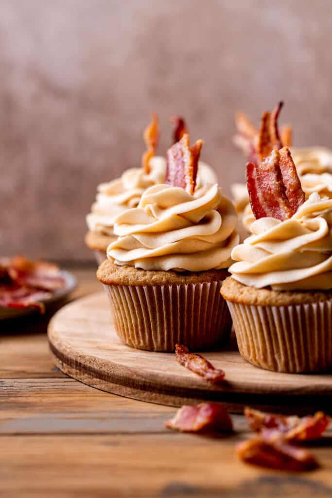 Decorated cupcakes on a wood board.