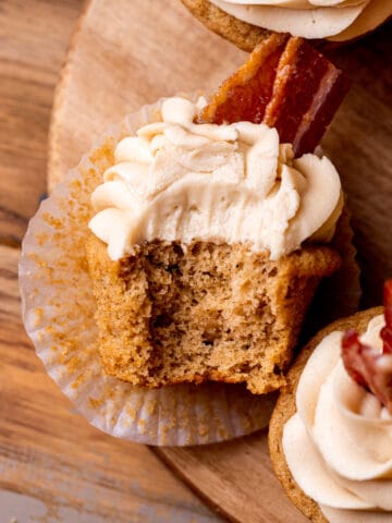 Top view of a maple bacon cupcake with a bite missing.