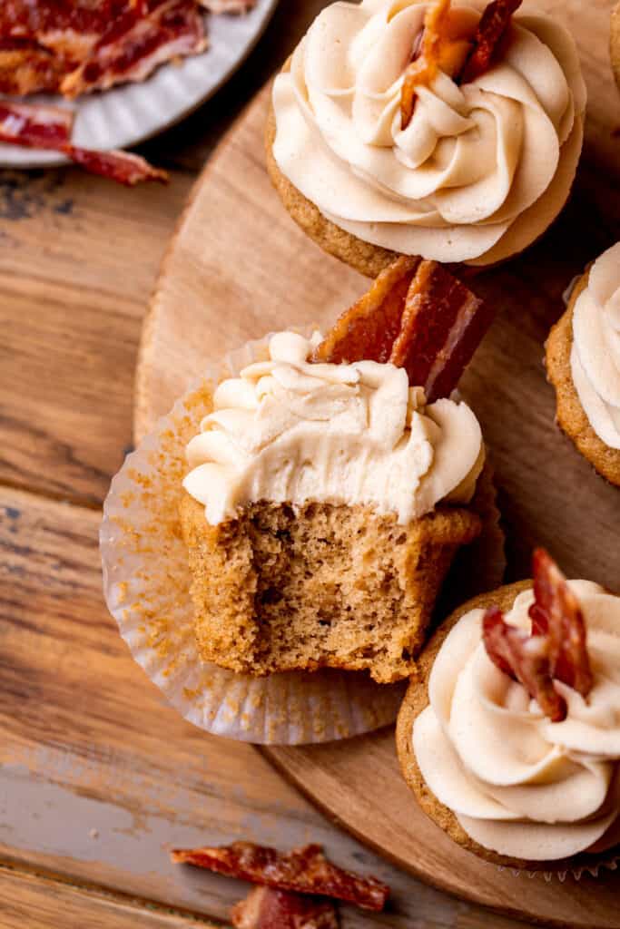 Top view of a maple bacon cupcake with a bite missing.