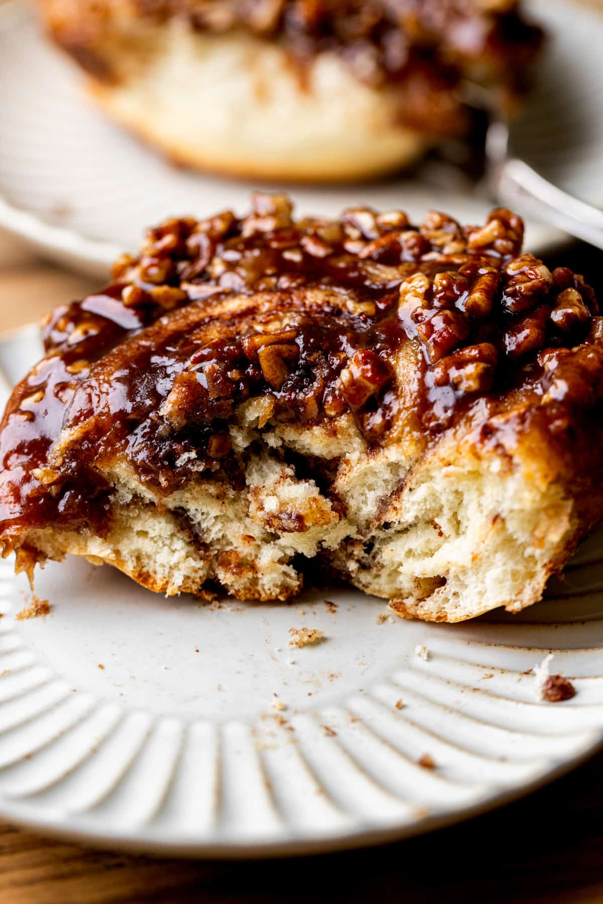 Side view of giant sticky bun on a plate.