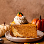 One slice of pumpkin cheesecake on a plate.