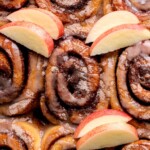Apple cider cinnamon rolls in a pan.