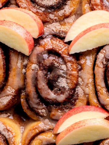 Apple cider cinnamon rolls in a pan.